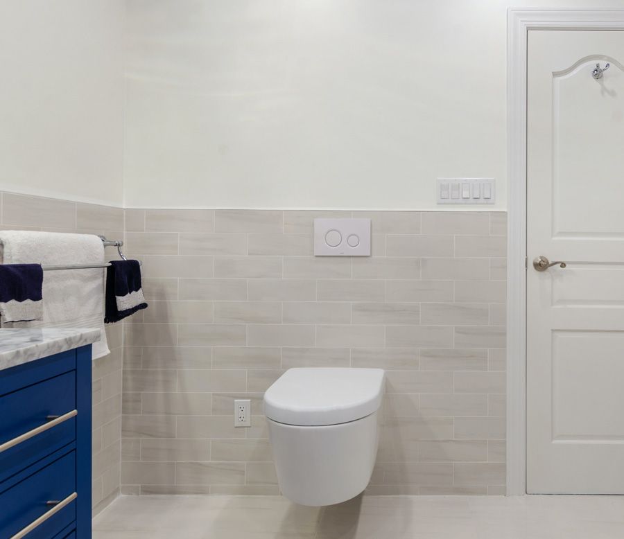 wall mounted toilet in a white and blue bathroom