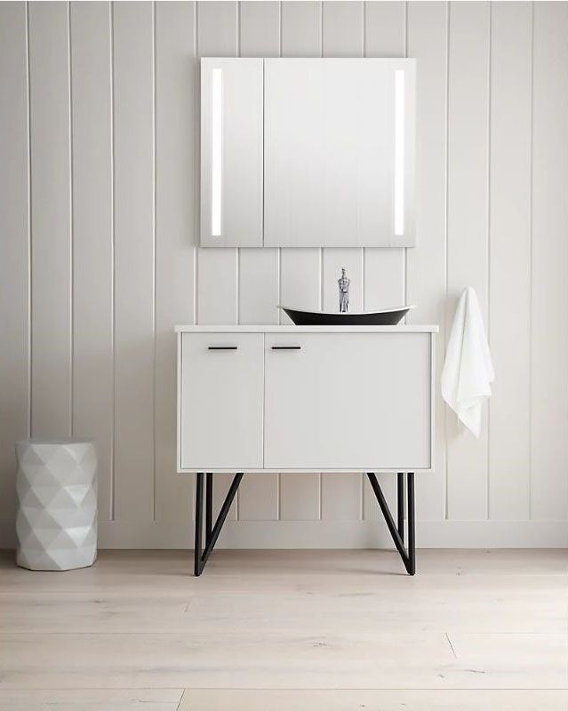 mirror medicine cabinet positioned above a white vanity