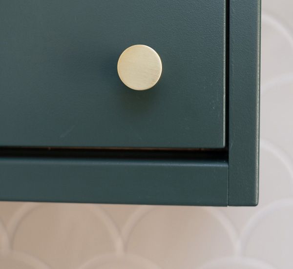 gold cabinet hardware on green cabinet door